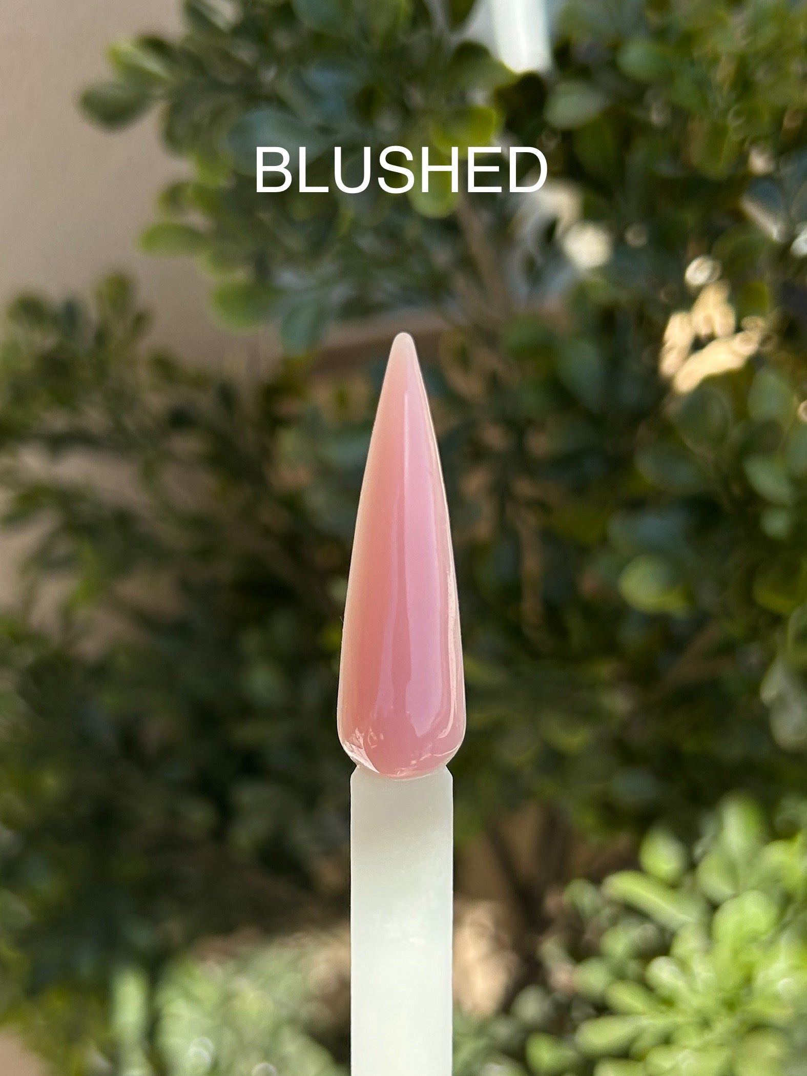 Nageltipp som visar upp builder gel i rosa nude färg med grön bakgrund.