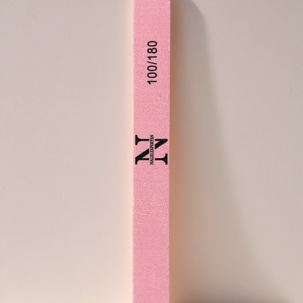 Rosa nagelfil med 100/180 grit som lutar mot en vägg.