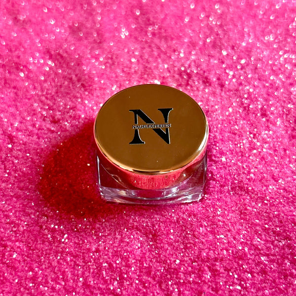 Burk med roseguldigt lock och rosa nagelglitter i bakgrunden.